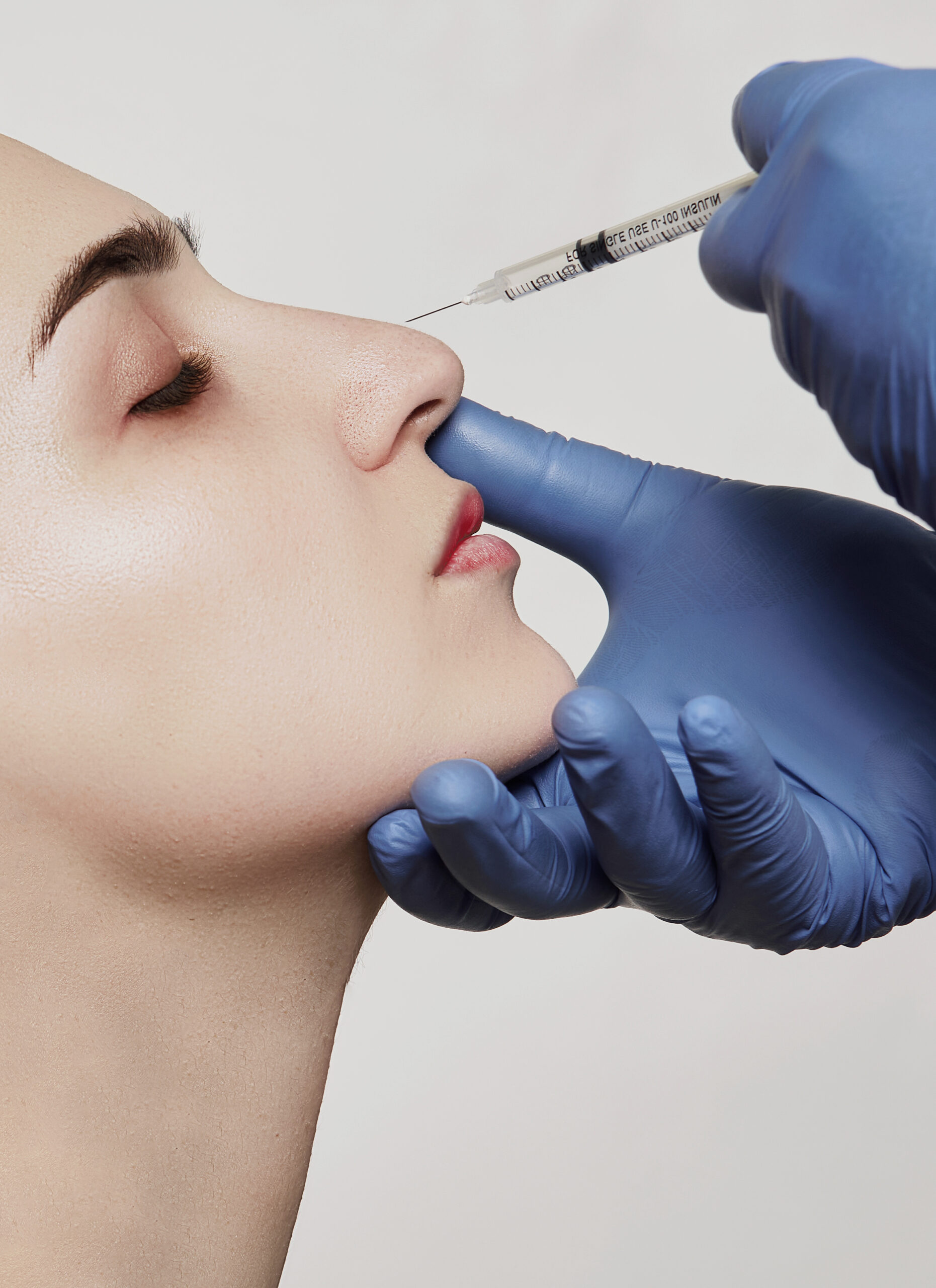 a woman getting a botox injection in her nose