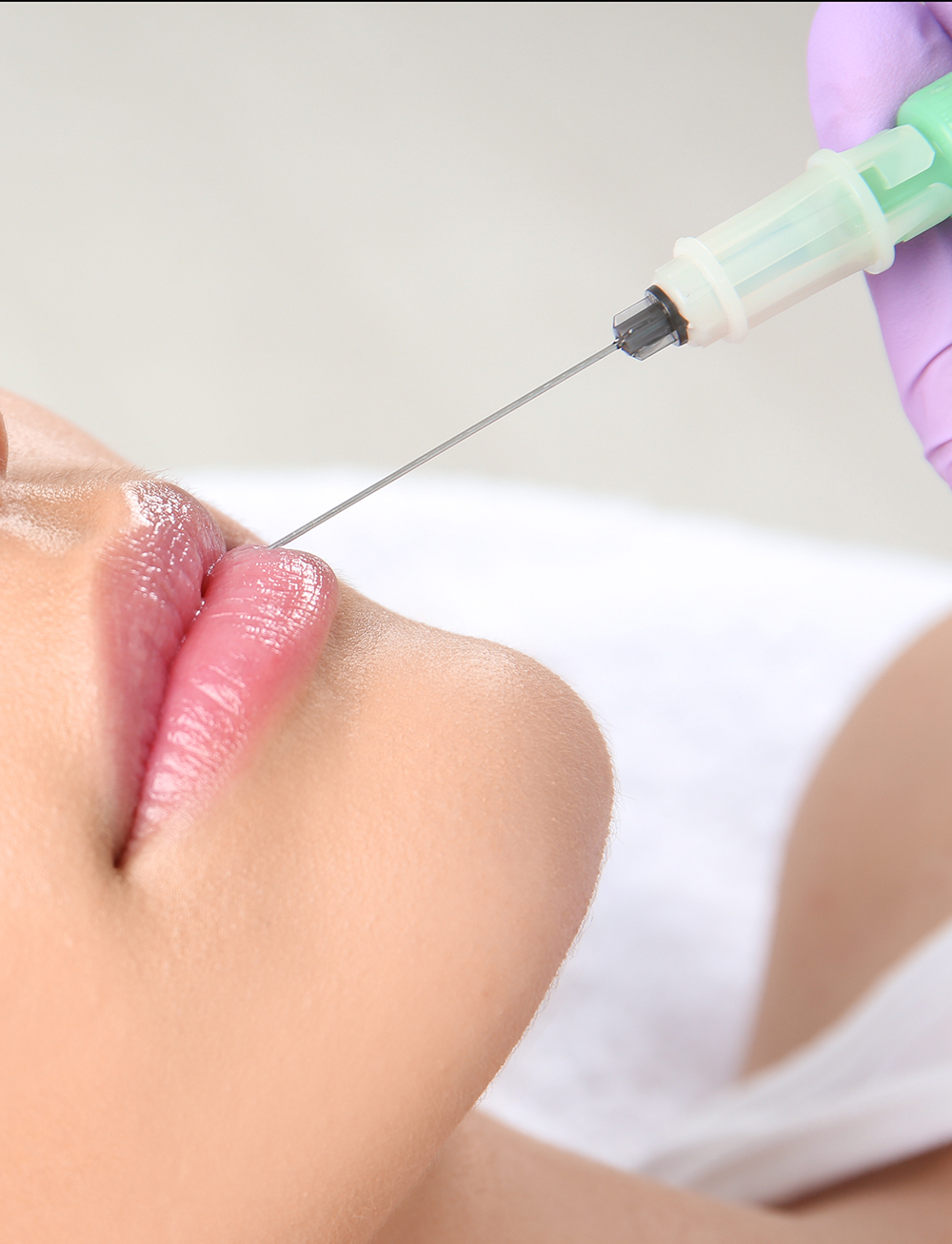 Young woman getting lip injection in beautician salon, closeup